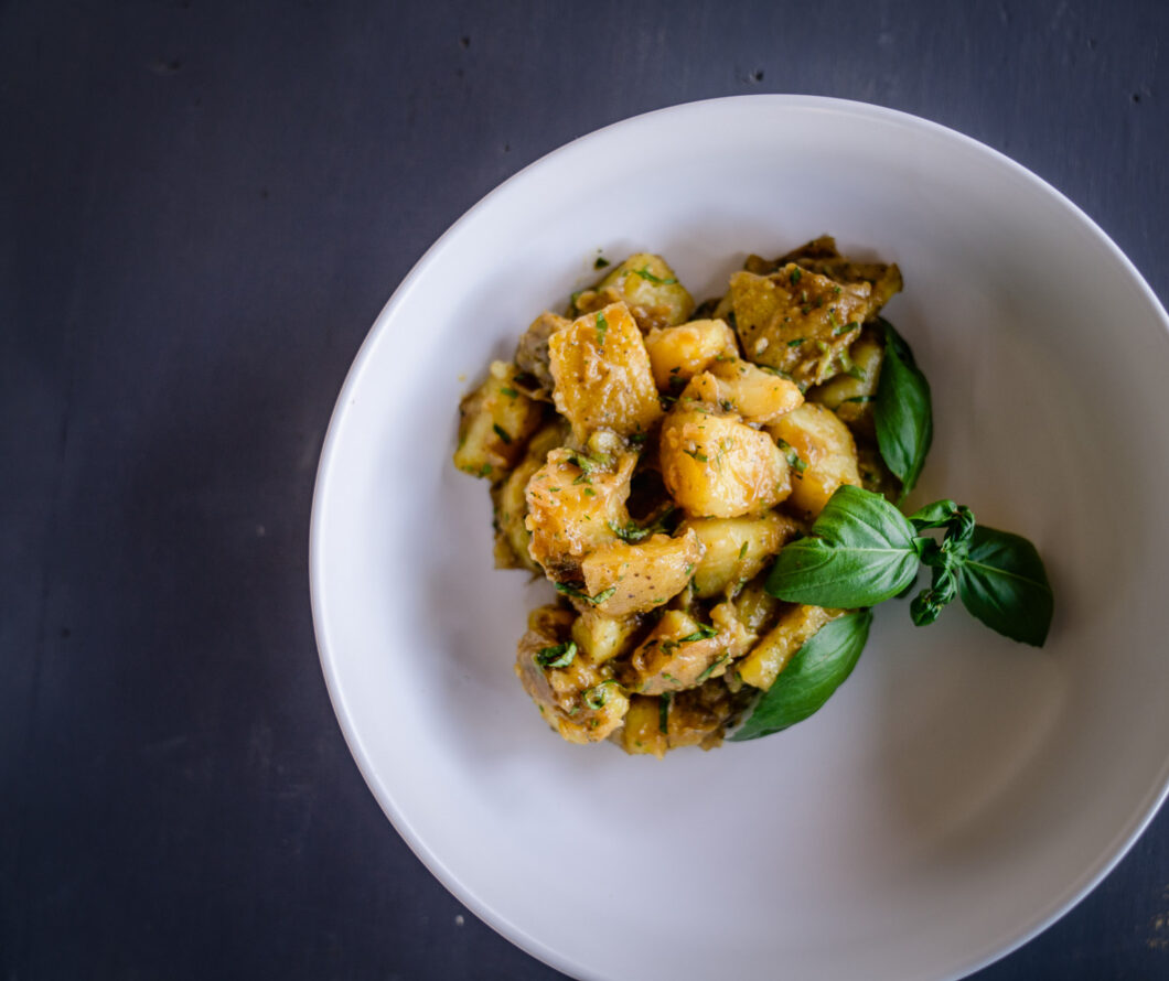 classic italian potato salad in a presentation dish with basil garnish
