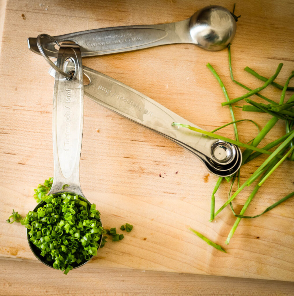 measuring spoon full of chopped herbs
