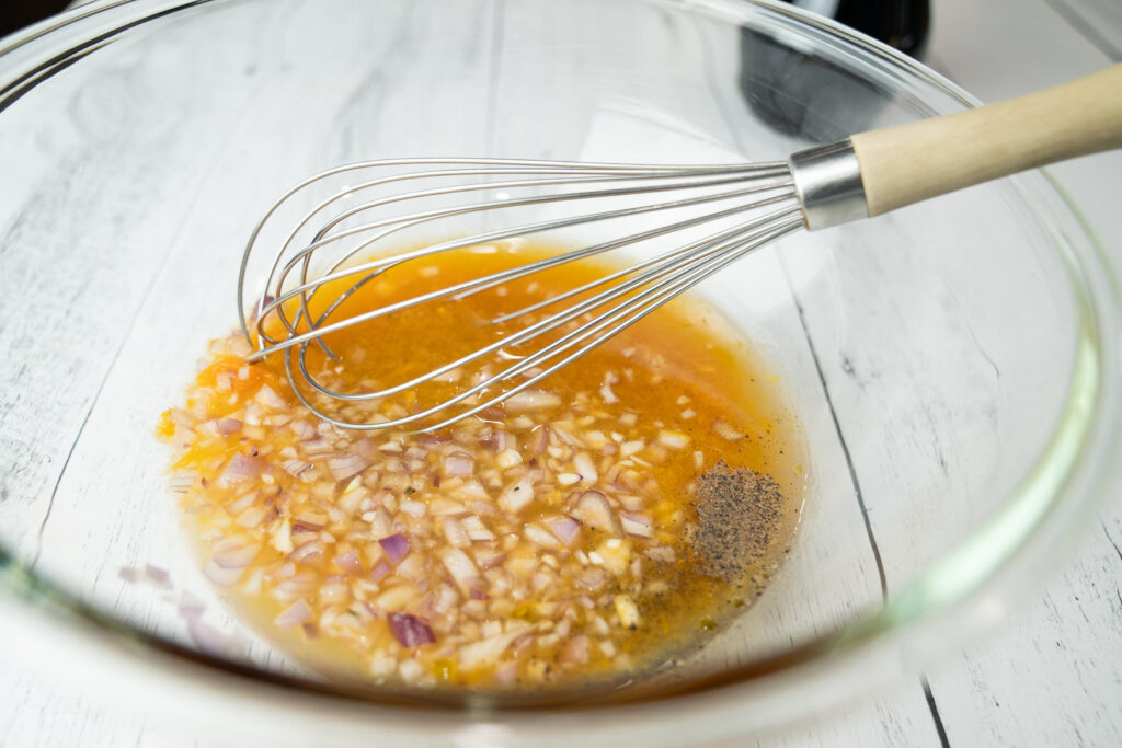 Apple cider vinaigrette ingredients in a mixing bowl