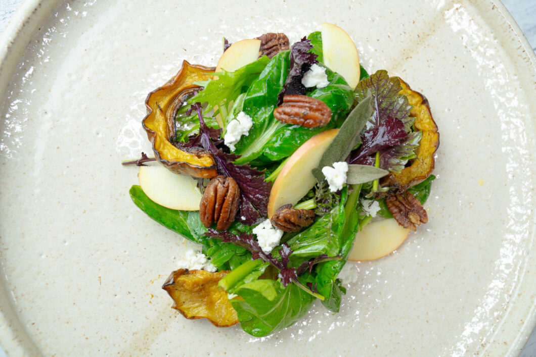 Delicata Squash Salad with Roasted Pecans and Apple Cider Vinaigrette salad presented on a serving plate
