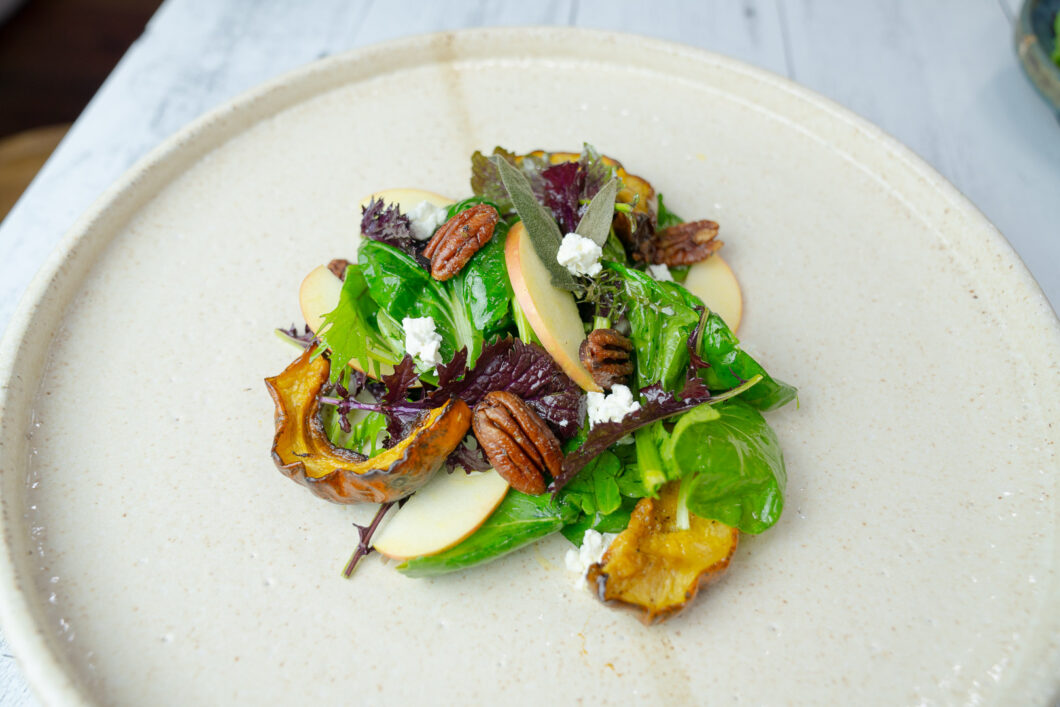 Delicata Squash Salad with Roasted Pecans and Apple Cider Vinaigrette on a serving plate