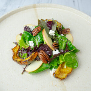 Delicata Squash Salad with Roasted Pecans and Apple Cider Vinaigrette on a serving plate