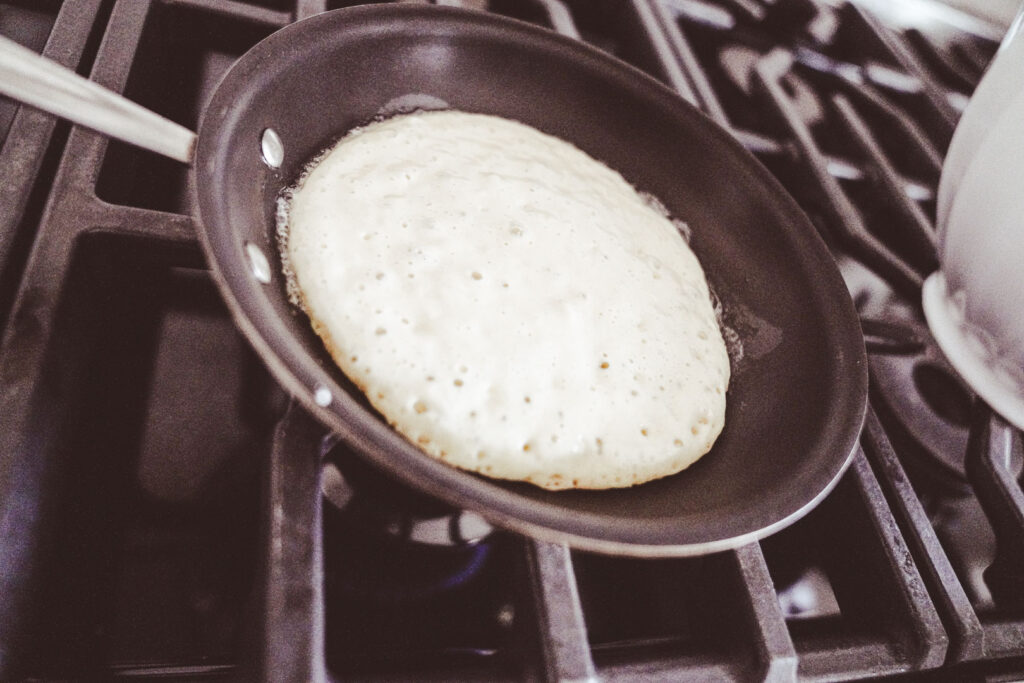 pancake batter cooking in a hot skillet